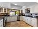 Well-lit kitchen features updated appliances, white cabinetry, and a garden window with a pool view at 4418 E Paradise Ln, Phoenix, AZ 85032