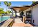 The covered patio boasts an outdoor kitchen, ample seating, and views of the sparkling pool at 4418 E Paradise Ln, Phoenix, AZ 85032