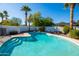 Sparkling swimming pool with a sun-soaked deck and a serene view of mature landscaping and palm trees at 4418 E Paradise Ln, Phoenix, AZ 85032