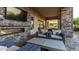 Cozy outdoor living space with a stone fireplace, comfortable seating, and a covered patio at 4535 E Navigator Ln, Phoenix, AZ 85050