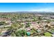 Breathtaking aerial perspective of a charming neighborhood featuring well-maintained homes, verdant trees, and refreshing pools under a sunny sky at 4634 E Wilshire Dr, Phoenix, AZ 85008