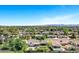 Picturesque aerial scene of a residential area featuring lush trees, well-kept homes, and sparkling pools beneath a clear blue sky at 4634 E Wilshire Dr, Phoenix, AZ 85008
