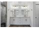 Dual sink bathroom featuring a large vanity, modern light fixtures, and framed mirrors at 4634 E Wilshire Dr, Phoenix, AZ 85008
