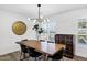 Elegant dining room with a wooden table, stylish chairs, modern lighting, and decorative accents against white walls at 4634 E Wilshire Dr, Phoenix, AZ 85008