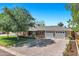 Charming single-story home featuring a brick exterior, a large front yard, and a spacious driveway with a three-car garage at 4634 E Wilshire Dr, Phoenix, AZ 85008