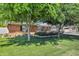 Well-maintained front yard with lush green grass, mature trees, and landscaped flower beds surrounding a charming brick home at 4634 E Wilshire Dr, Phoenix, AZ 85008
