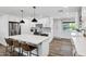 Modern kitchen featuring white cabinetry, stainless steel appliances, island with seating, and wood-look flooring at 4634 E Wilshire Dr, Phoenix, AZ 85008