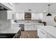 Bright kitchen with white cabinets, stainless steel appliances, farmhouse sink, and wood-look flooring at 4634 E Wilshire Dr, Phoenix, AZ 85008