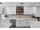 Beautiful kitchen featuring white cabinetry, open shelving, stainless steel appliances, and a farmhouse sink at 4634 E Wilshire Dr, Phoenix, AZ 85008