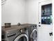 Modern laundry room with side-by-side washer and dryer and outdoor access at 4634 E Wilshire Dr, Phoenix, AZ 85008