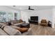 Modern living room with a comfortable sectional sofa, hardwood floors, a ceiling fan, and large windows with shutters at 4634 E Wilshire Dr, Phoenix, AZ 85008