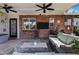 Covered patio featuring brick accent wall, mounted TV, ceiling fans, and wicker furniture at 4634 E Wilshire Dr, Phoenix, AZ 85008