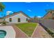 Well-maintained backyard boasts a charming patio area, lush lawn, and convenient pool access at 4902 E Golden St, Mesa, AZ 85205