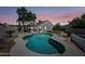 Backyard featuring a serene pool area, tropical landscaping, and a lovely home exterior at 4902 E Golden St, Mesa, AZ 85205