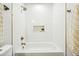 Modern bathroom featuring a sleek white tub and shower with stylish gold fixtures at 4902 E Golden St, Mesa, AZ 85205
