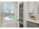 A walk-in pantry with white shelving and a glimpse of the pool outside the window at 4902 E Golden St, Mesa, AZ 85205