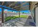 Covered patio offers shade and a spot to relax in a backyard with a grassy lawn, desert landscaping and privacy fence at 4902 E Golden St, Mesa, AZ 85205