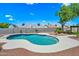 Beautiful backyard pool with rock landscaping features a tanning ledge and nearby shade and seating area at 4902 E Golden St, Mesa, AZ 85205