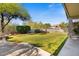 Spacious backyard with a fountain, lush grass, and mature trees at 5090 E Sleepy Ranch Rd, Cave Creek, AZ 85331