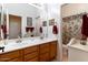 Bathroom featuring double sinks, wood cabinets, and a shower with patterned curtains at 5090 E Sleepy Ranch Rd, Cave Creek, AZ 85331