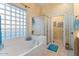 Bathroom with a soaking tub, shower, and glass block window for natural light at 5090 E Sleepy Ranch Rd, Cave Creek, AZ 85331