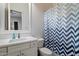 Compact bathroom with a white vanity, patterned shower curtain, and functional layout at 6535 W Gold Mountain Pass, Phoenix, AZ 85083