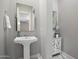 Charming powder room with a pedestal sink, elegant mirror, and stylish decor at 6535 W Gold Mountain Pass, Phoenix, AZ 85083