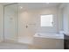 Bright bathroom featuring a tub, and a separate glass-enclosed shower at 6728 N 190Th Dr, Waddell, AZ 85355
