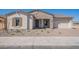 Inviting single-story home with a stone facade, low-maintenance landscaping, and a welcoming front porch at 6728 N 190Th Dr, Waddell, AZ 85355