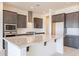 Close-up of kitchen island featuring granite countertops, a stainless steel sink, and dark wood cabinetry at 6728 N 190Th Dr, Waddell, AZ 85355