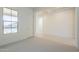 Bright, open living space with a large window, neutral carpet, and a view into the hallway at 6728 N 190Th Dr, Waddell, AZ 85355
