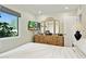 Comfortable bedroom featuring a dresser with a large mirror, a window, and a door to another room at 6800 E Exeter Blvd, Scottsdale, AZ 85251