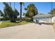 Wide driveway leads to a two-car garage, surrounded by mature trees and manicured landscaping at 6800 E Exeter Blvd, Scottsdale, AZ 85251