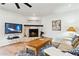 Living room showcasing hardwood floors, a decorative fireplace, a ceiling fan and a flat screen tv at 6800 E Exeter Blvd, Scottsdale, AZ 85251