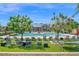 Relaxing community pool area with lounge chairs, artificial grass, and shade trees for residents at 687 W Flintlock Way, Chandler, AZ 85286