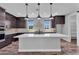 Contemporary kitchen featuring dark wood cabinets, quartz countertops, and modern pendant lights at 687 W Flintlock Way, Chandler, AZ 85286