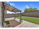 Cozy covered patio with brick pavers, artificial turf, and string lights for outdoor relaxation at 687 W Flintlock Way, Chandler, AZ 85286