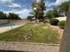 View of backyard with pool, green grass, gravel and landscaping at 7176 W Blackhawk Dr, Glendale, AZ 85308