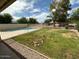 View of backyard with pool, green grass, gravel and landscaping at 7176 W Blackhawk Dr, Glendale, AZ 85308