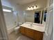 Bright bathroom featuring a bathtub and shower combination with white tile surround and a vanity with ample countertop space at 7176 W Blackhawk Dr, Glendale, AZ 85308