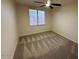 Neutral bedroom with a large window with a ceiling fan and neutral carpeting throughout at 7176 W Blackhawk Dr, Glendale, AZ 85308
