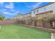 Spacious backyard with artificial turf, brick retaining wall, and blooming shrubs, perfect for outdoor enjoyment at 7234 W Aire Libre Ave, Peoria, AZ 85382