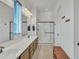 Bright bathroom featuring double sinks, large mirror, walk-in shower, and a wooden bench at 7234 W Aire Libre Ave, Peoria, AZ 85382