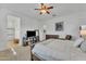Spacious main bedroom with a ceiling fan, tv, and access to an ensuite bathroom at 7234 W Aire Libre Ave, Peoria, AZ 85382