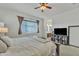 Comfortable main bedroom featuring a king bed, tv, and adjacent bathroom at 7234 W Aire Libre Ave, Peoria, AZ 85382