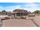Large backyard with covered patio, outdoor kitchen, pergola, and ample stone landscape at 7524 E Leland Cir, Mesa, AZ 85207