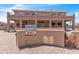Outdoor kitchen with built-in stainless steel grill and granite countertops, set in a brick-paved backyard at 7524 E Leland Cir, Mesa, AZ 85207