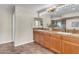 Bathroom featuring double sinks, wood cabinets, tile floor, and glass block window at 7524 E Leland Cir, Mesa, AZ 85207