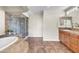 Bright bathroom with tub, glass shower, wooden cabinets and modern fixtures at 7524 E Leland Cir, Mesa, AZ 85207