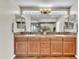 Double sink bathroom with wood cabinets, decorative lighting, and modern decor at 7524 E Leland Cir, Mesa, AZ 85207